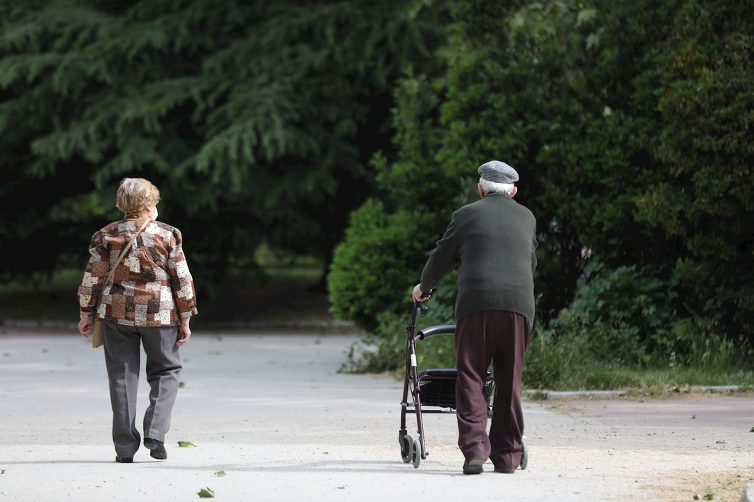 Una mujer y un hombre de edad avanzada con andador paseando. En Madrid, (España), a 7 de mayo de 2020.
