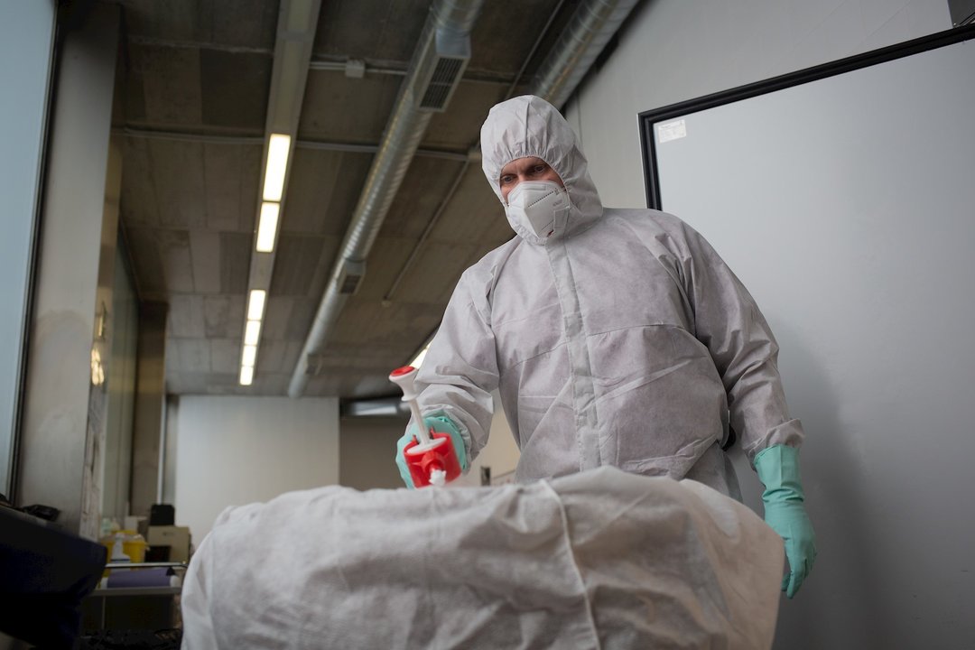 Un operario del Crematorio de Girona desinfecta el cuerpo de una persona fallecida con Covid-19 y su ataúd, antes de introducirle en el horno crematorio