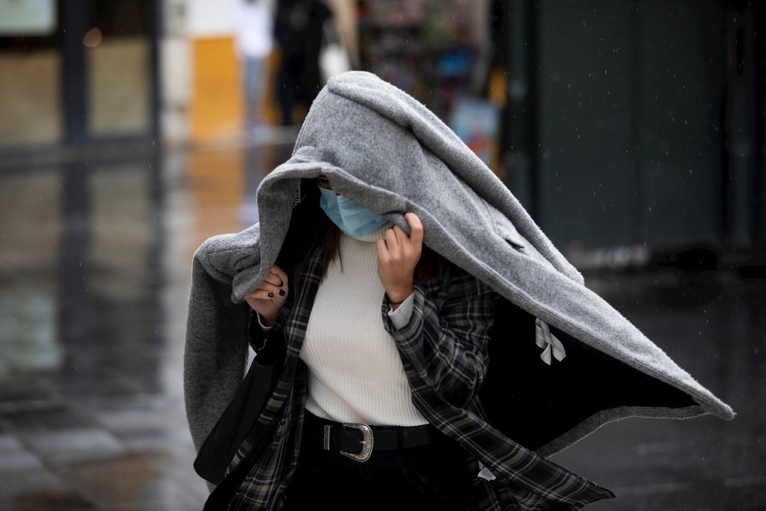 Foto de archivo. Una persona se protege de la lluvia con un abrigo.