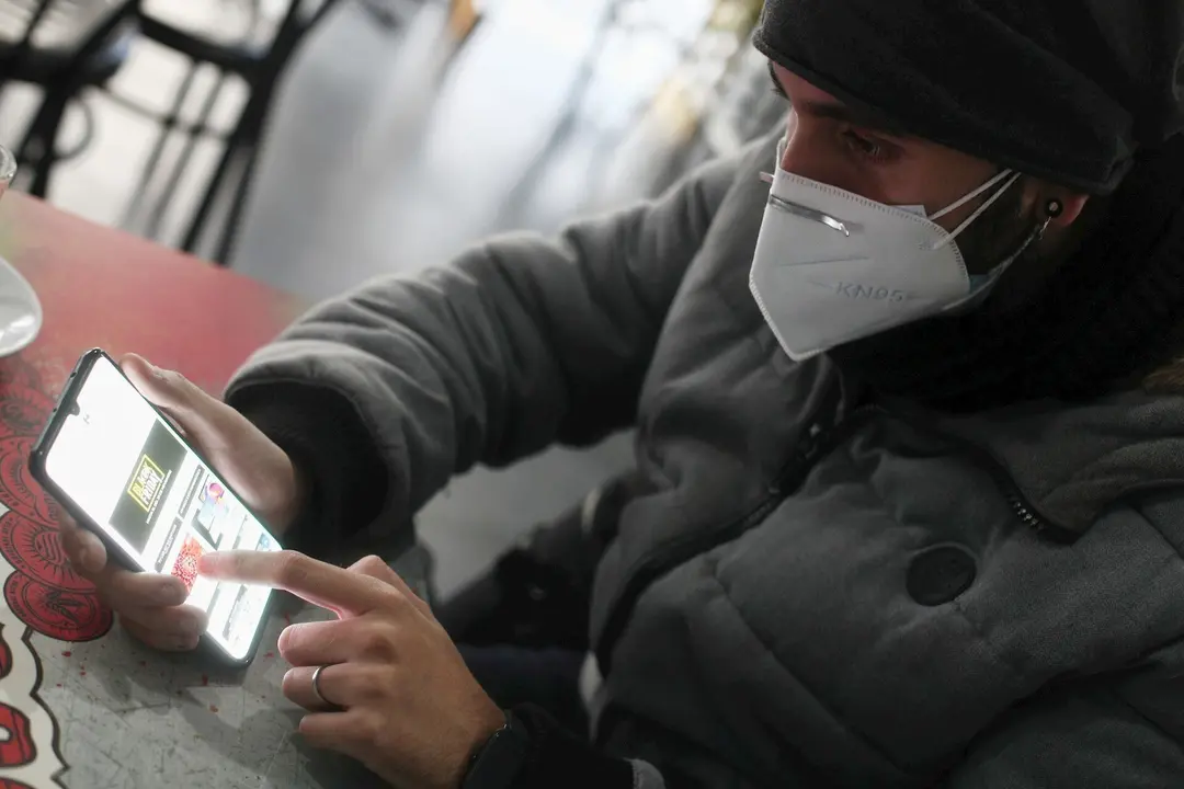 Un joven consulta las ofertas de Black Friday de un comercio en su m&oacute;vil, en Madrid (Espa&ntilde;a), a 15 de noviembre de 2020. Debido a las dificultades para comprar en los establecimientos f&iacute;sicos impuestas por la pandemia, en el Black Friday de 2020 las cifra