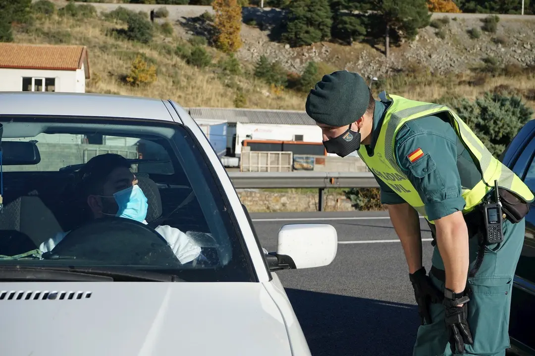 Un agente de la Guardia Civil le pide la documentaci&oacute;n al conductor de un veh&iacute;culo durante un control de movilidad en la carretera AP-6 de acceso a Segovia, Castilla y Le&oacute;n, (Espa&ntilde;a), a 30 de octubre de 2020.