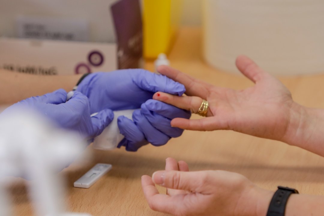 Personal sanitario de Cruz Roja saca sangre de un dedo a una persona para realizar el test rápido de detección de anticuerpos IgG e IgM en el Instituto de Formación Integral en Seguridad y Emergencias (IFISE), en Colmenar Viejo, Madrid, a 2 de septiembre