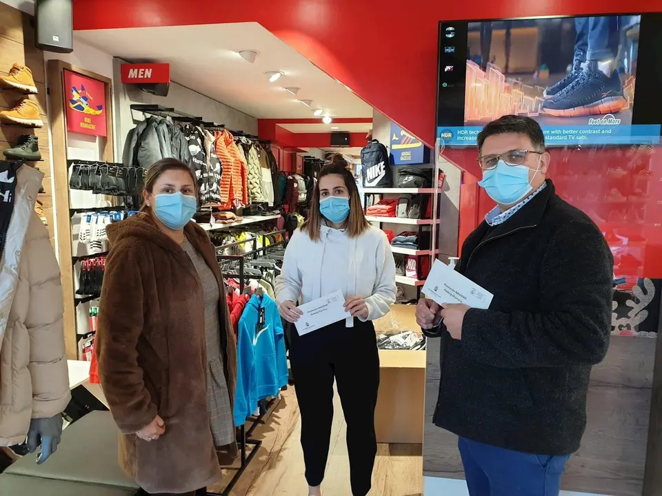 El concejal de Comercio, Vicente Palazuelos, junto a la concejala de Comunicaci&oacute;n, Cristina Laza, haciendo entrega de unos tickets a un comercio local