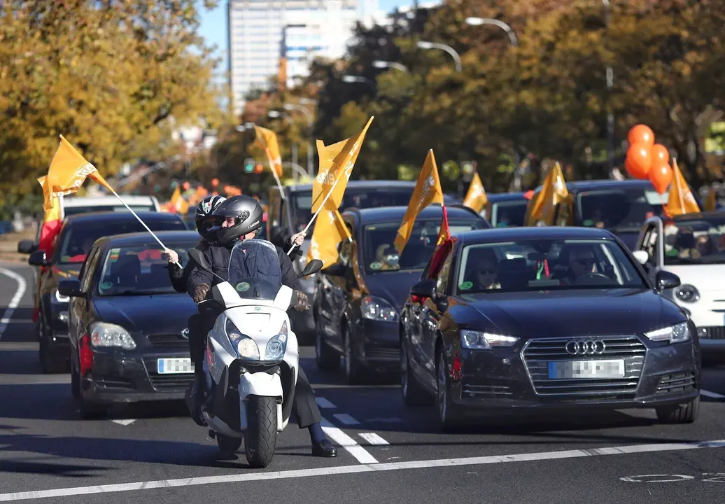 Varias personas muestran a trav&eacute;s de sus coches banderas y globos de color naranja durante una manifestaci&oacute;n de veh&iacute;culos en apoyo a la educaci&oacute;n concertada y contra la Ley Cela&aacute;, en Madrid, el pasado 22 de noviembre