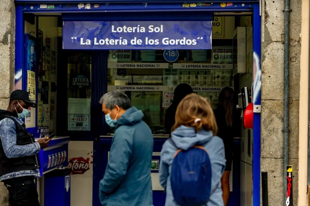 Varias personas hacen cola en las inmediaciones de la administraci&oacute;n de loter&iacute;a Sol donde venden boletos para el Sorteo Extraordinario de la Loter&iacute;a de Navidad 2020, en Madrid (Espa&ntilde;a), a 4 de noviembre de 2020. A un mes y medio del tradicional sorteo, la