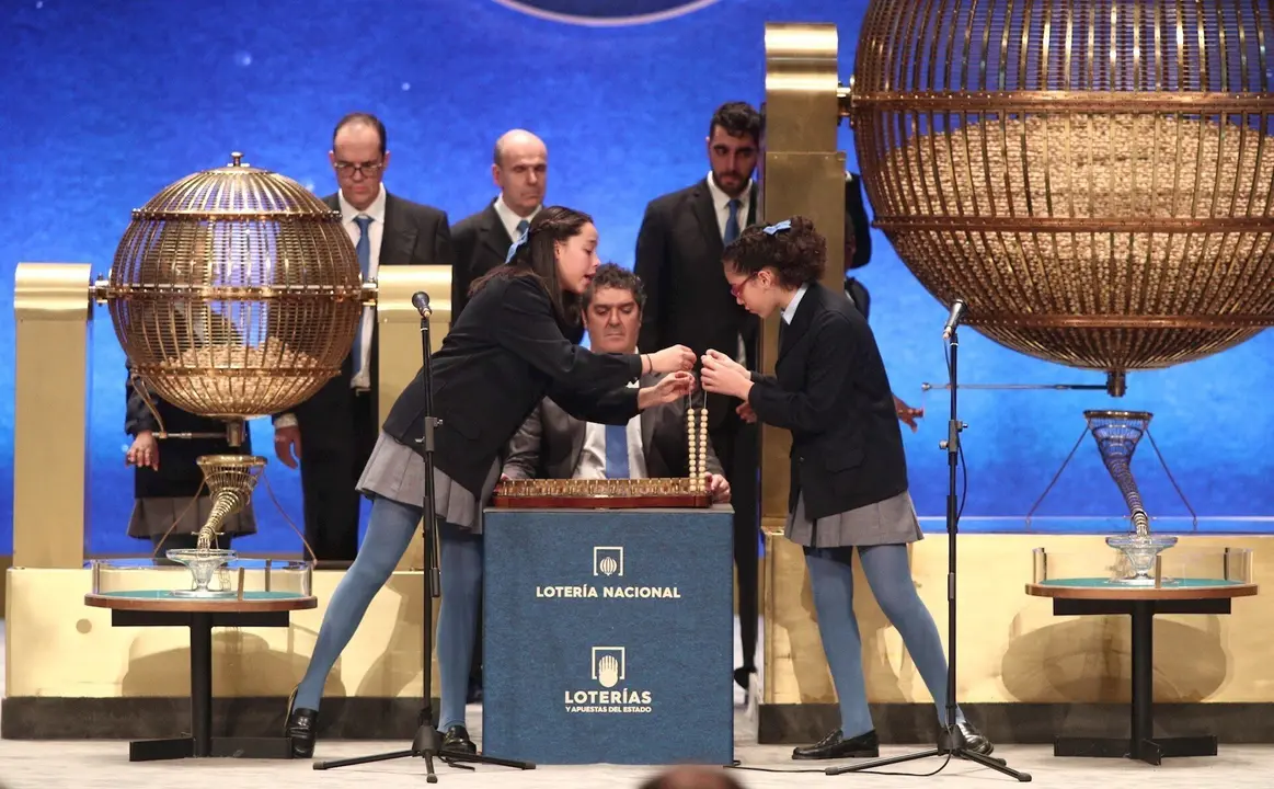 Las dos ni&ntilde;as de la residencia de San Ildefonso, Noura Akrouh (dech) y Elisabeth del Carmen Roque Figuereo (izq), durante el canto de la primera tabla de la Loter&iacute;a de Navidad, en el que ha salido el Primer Premio de la Loter&iacute;a de Navidad, el Gordo de la 