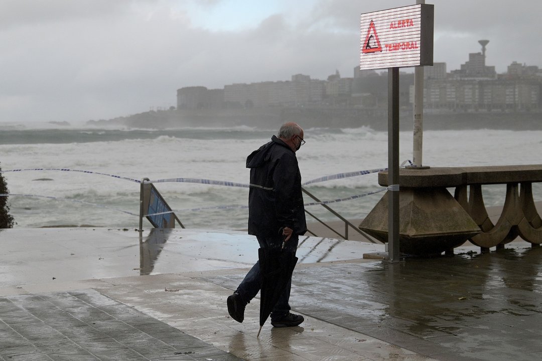Un hombre en la Playa de Riazor durante un temporal costero en A Coruña, Galicia (España), a 4 de diciembre de 2020. La Dirección Xeral de Emerxencias e Interior de la Vicepresidencia Primera de la Xunta ha elevado a roja la alerta por temporal costero en