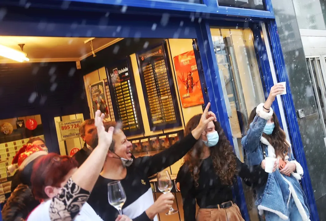 Loteros y clientes de una administraci&oacute;n de Loter&iacute;a brindan despu&eacute;s de la celebraci&oacute;n del sorteo, en Ferrol (A Coru&ntilde;a)