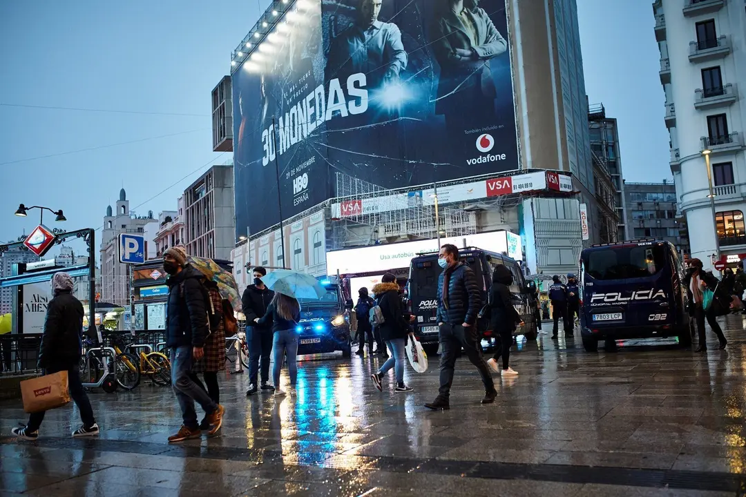 Transe&uacute;ntes caminan cerca de una zona comercial en la calle de Preciados, en Madrid (Espa&ntilde;a)