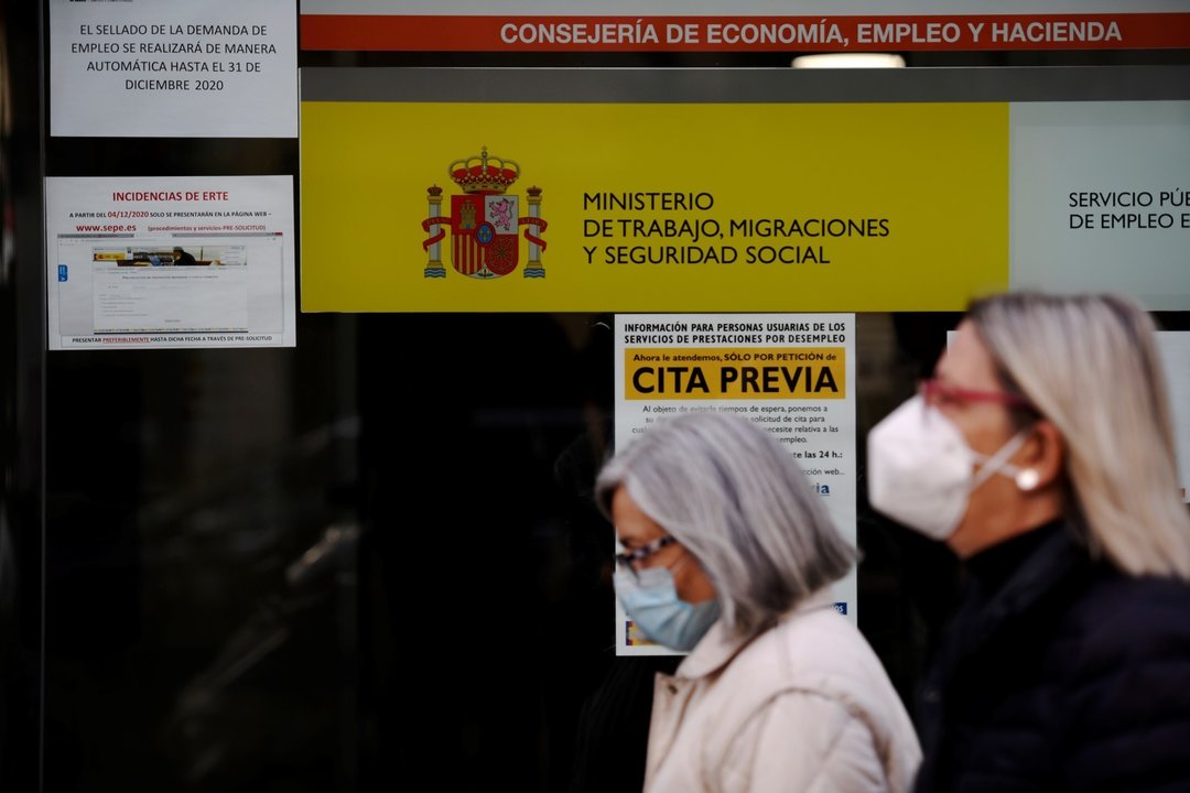 Dos mujeres pasan por la puerta de una oficina de empleo, SEPE (antiguo INEM) horas después de conocer los datos del paro de noviembre, en Madrid (España), a 2 de diciembre de 2020. 