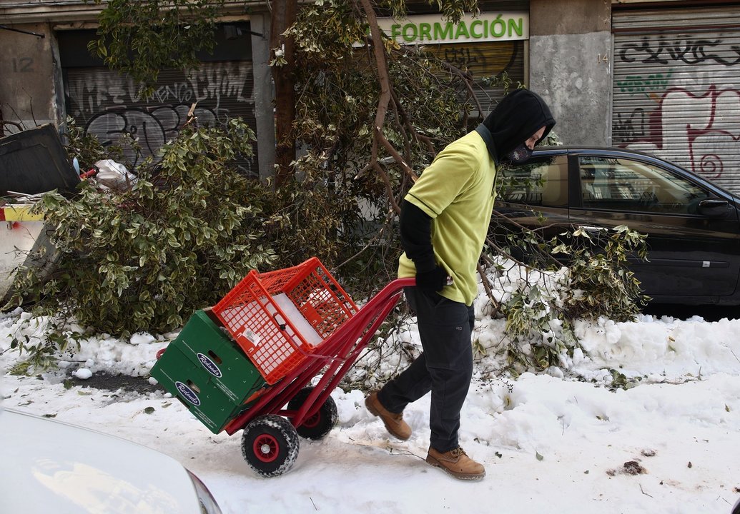 Un hombre arrastra una carretilla por una calle del centro aún con nieve y árboles caídos en Madrid (España), a 13 de enero de 2021. Madrid sigue cubierto de nieve cinco días después de la gran nevada provocada por el paso de la borrasca ‘Filomena’. El Ay