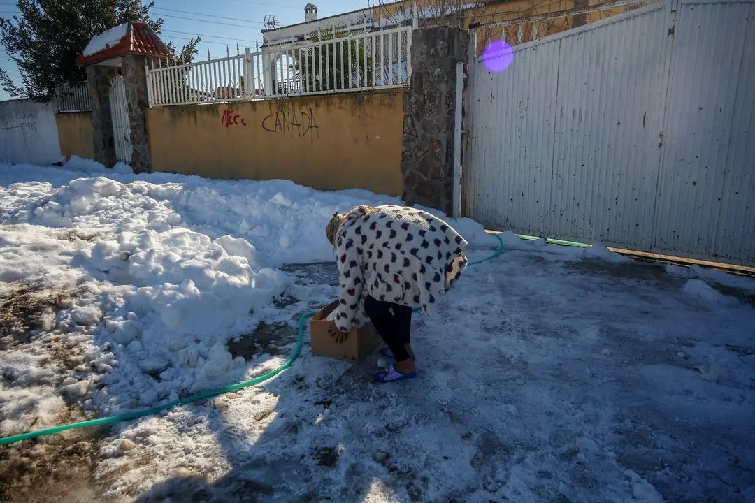 Una vecina de la Ca&ntilde;ada Real con una caja de bienes de primera necesidad de Cruz Roja.