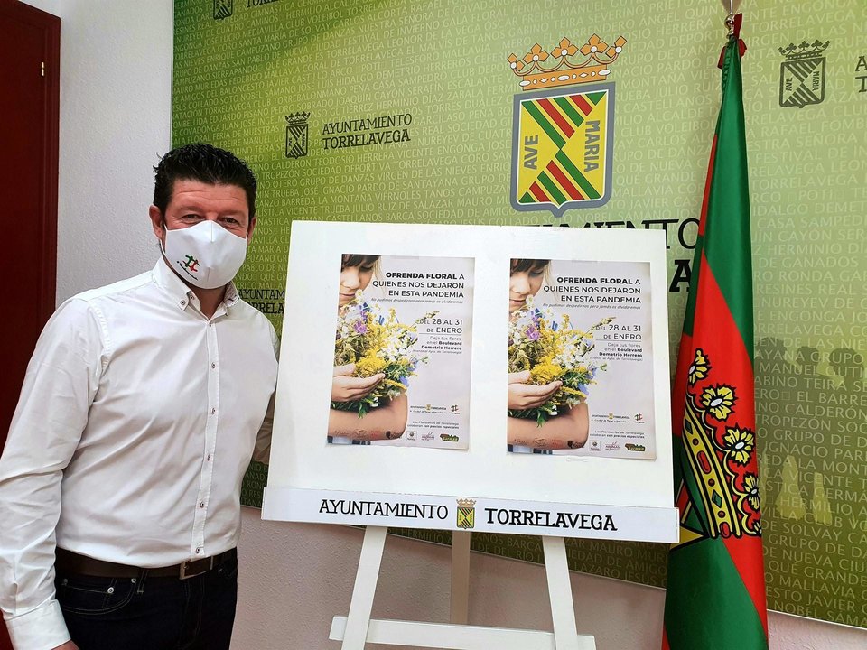 El concejal de Dinamización Social de Torrelavega, Jesús Sánchez, junto al carte de la ofrenda floral a los fallecidos del Covid