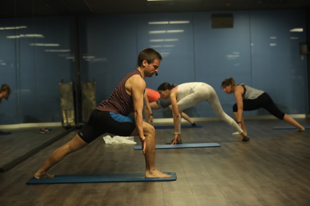 Un entrenador imparte clase a varias personas en una clase de Body Balance en un gimnasio de la cadena O2 en Madrid (España) 