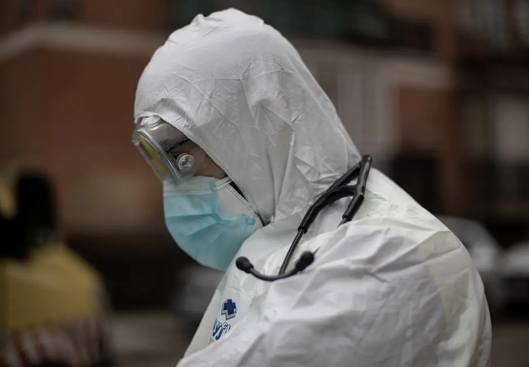 Un trabajador de una UVI m&oacute;vil del SUMMA 112 con el EPI asiste un domicilio durante una jornada de trabajo, en Madrid (Espa&ntilde;a), a 29 de enero de 2021.