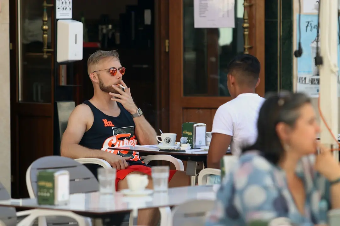 Una persona fuma en una terraza durante el primer d&iacute;a de la prohibici&oacute;n de realizarlo en la v&iacute;a p&uacute;blica en M&aacute;laga, (Andaluc&iacute;a, Espa&ntilde;a), a 17 de agosto de 2020.