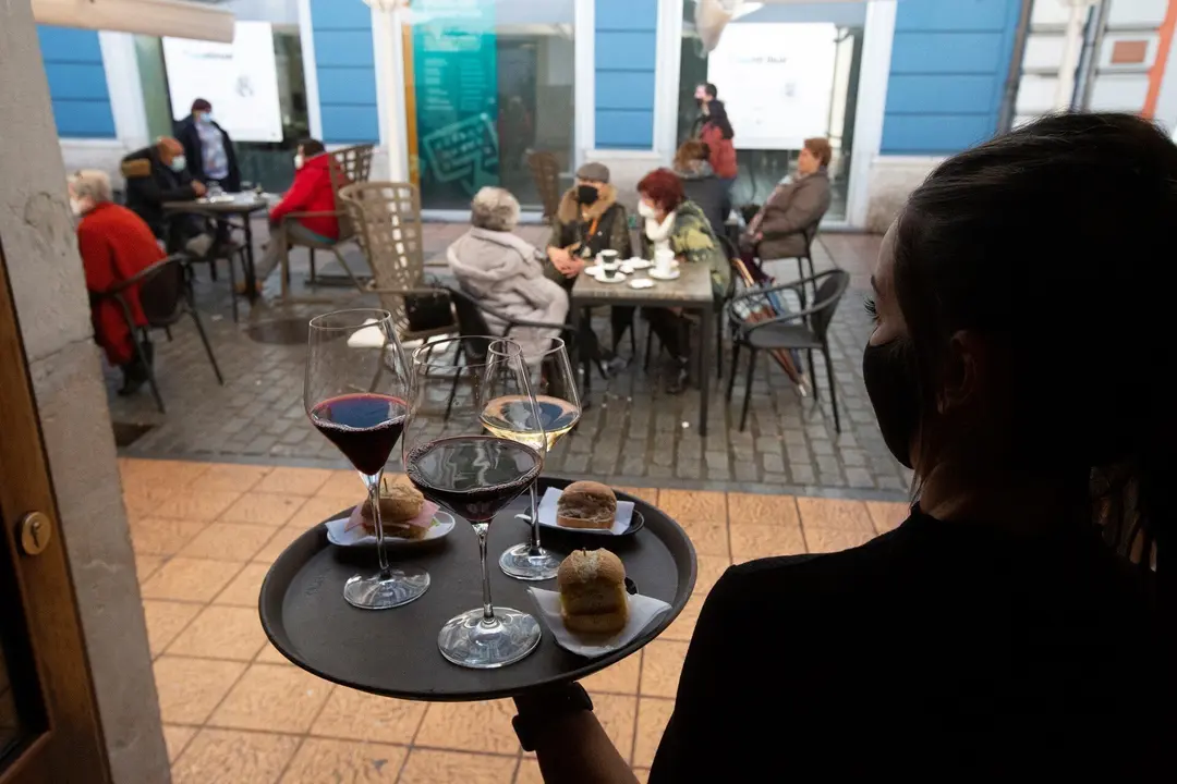 Una camarera se dispone a servir en una terraza de un restaurante