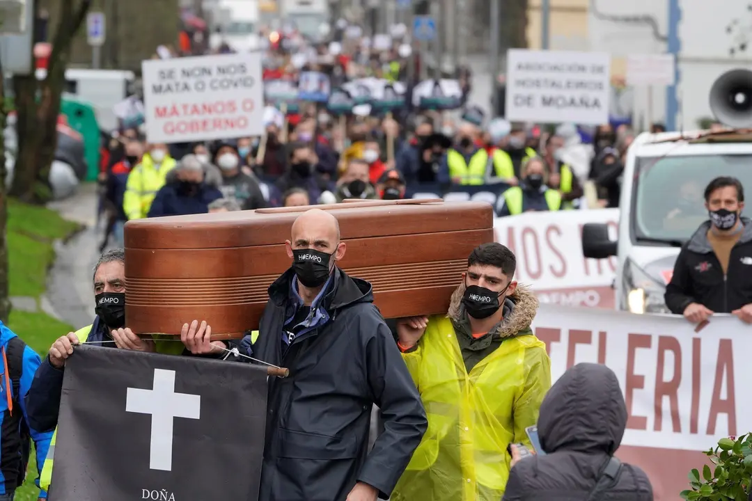 Trabajadores del sector hostelero sostienen una l&agrave;pida frente a la Xunta de Galicia como signo de protesta, en Santiago de Compostela, A Coru&ntilde;a, Galicia, (Espa&ntilde;a),  