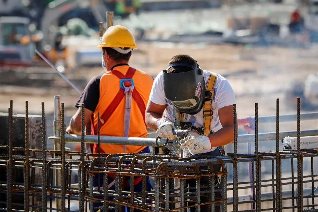 Archivo - Un soldador y un operario trabajando