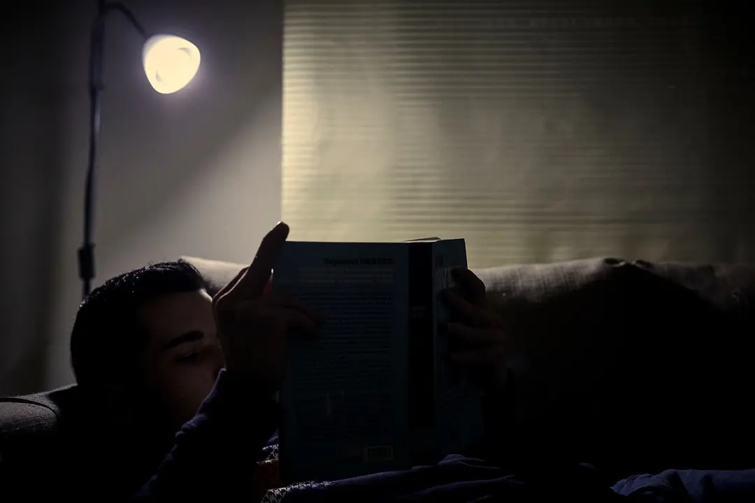 Archivo - Un chico lee un libro bajo la luz de una l&aacute;mpara en Madrid (Espa&ntilde;a), a 12 de enero de 2021. El precio mayorista de la electricidad subir&aacute; este martes un 2,18% con respecto al marcado este lunes, manteni&eacute;ndose as&iacute; por encima de los 80 euros por m