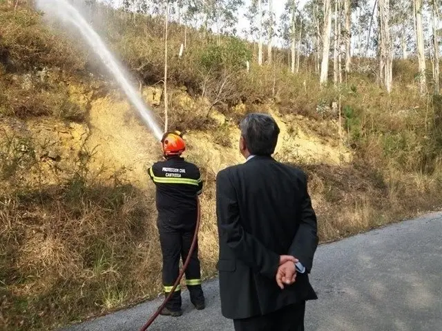 Archivo - El jefe de la agrupaci&oacute;n de Protecci&oacute;n Civil apaga un incendio mientras Revilla le observa, d&iacute;as antes de ser acusado como presunto autor del incendio de La Alcomba