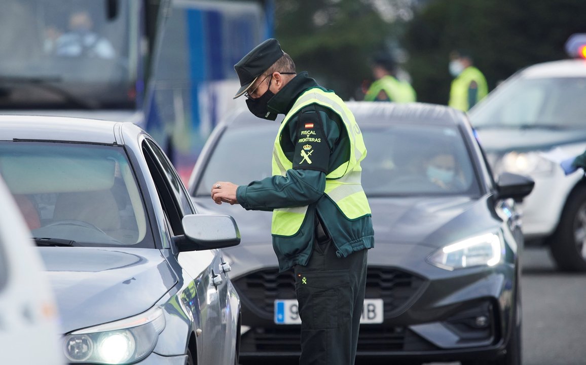 Archivo - Un agente de la Guardia Civil pide la documentación a un vehículo durante un control efectuado en Laredo, Cantabria.
