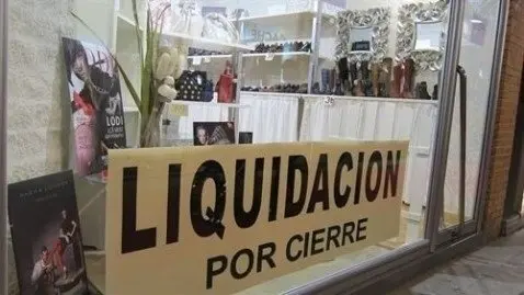 Archivo - Cartel liquidaci&oacute;n por cierre en un peque&ntilde;o comercio tradicional