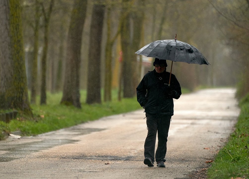 Archivo - Una persona se refugia con un paraguas de la lluvia en Vitoria, País Vasco (España), a 19 de marzo de 2021.
