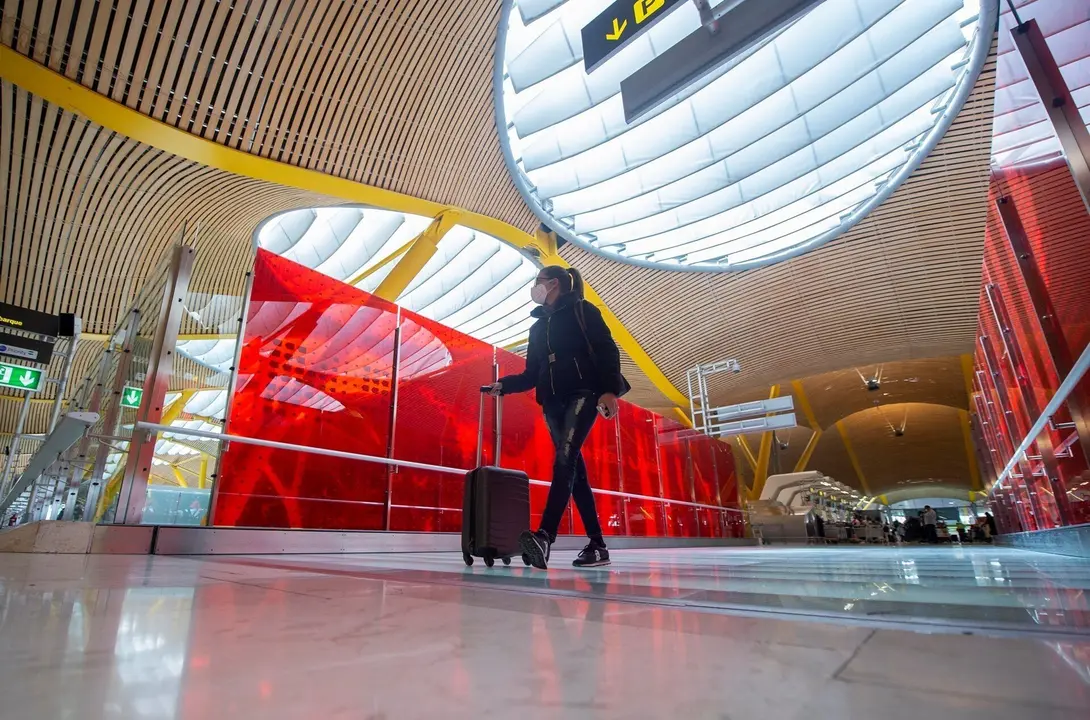 Una pasajera desplaza su maleta por las instalaciones de la T4 del Aeropuerto Adolfo Su&aacute;rez Madrid-Barajas, en Madrid (Espa&ntilde;a), a 26 de marzo de 2021. Un total de 4.818 efectivos de las Fuerzas y Cuerpos de Seguridad del Estado (FCSE) se desplegar&aacute;n esta 