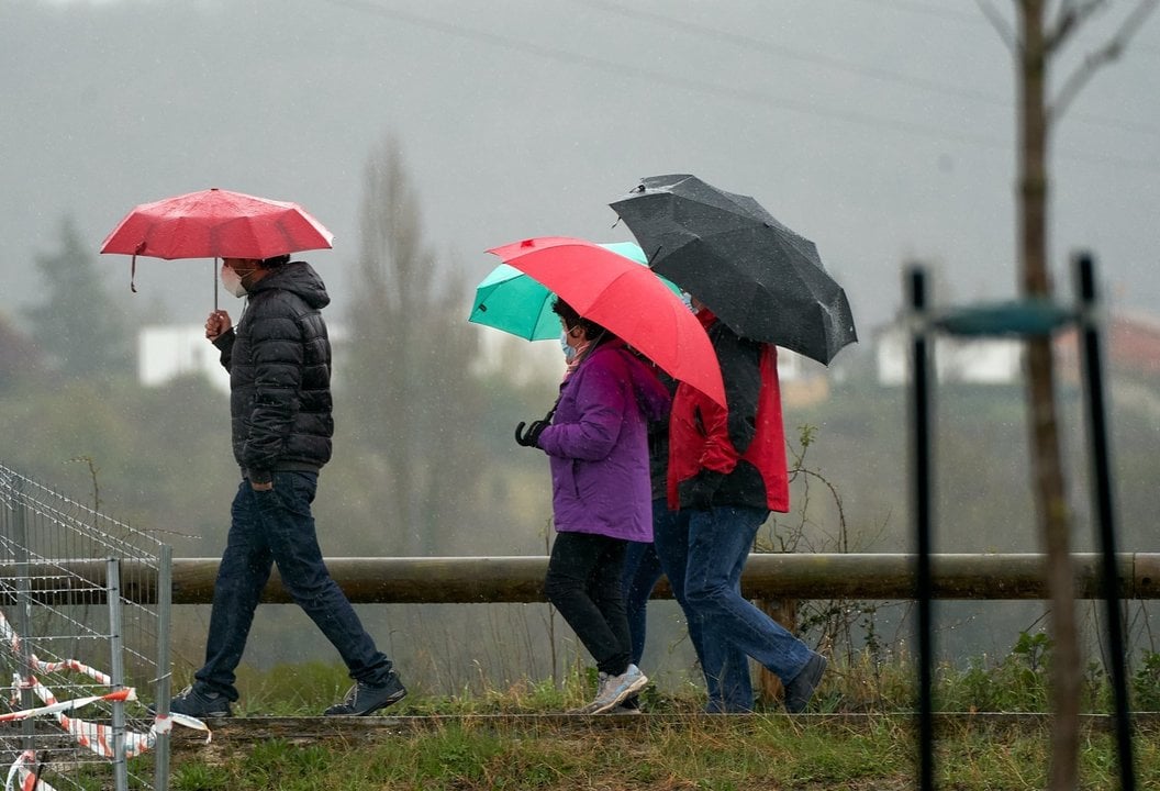 Archivo - Varias personas se refugian con un paraguas de la lluvia en Vitoria, País Vasco (España), a 19 de marzo de 2021. 