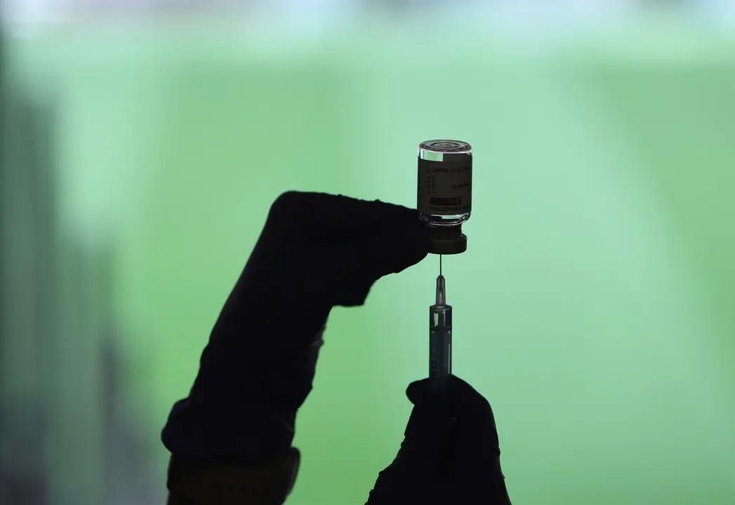 Un profesional sanitaria sostiene una jeringuilla y un vial con la vacuna del Covid-19, en un dispositivo instalado en el Estadio Wanda Metropolitano, en Madrid (Espa&ntilde;a), a 30 de marzo de 2021.