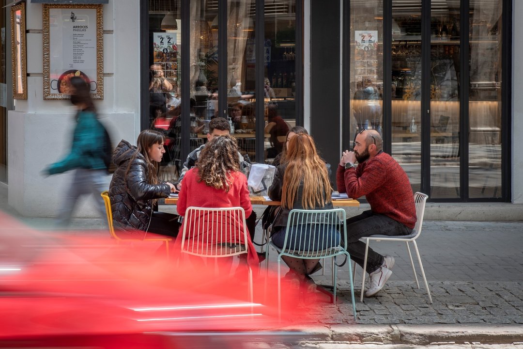 Seis personas sentadas en una terraza el día en que se amplían a seis los comensales por mesa, a 12 de abril de 2021, en Valencia, Comunidad Valenciana (España). A partir de hoy, seis personas podrán sentarse juntas en bares y terrazas. También se flexibi
