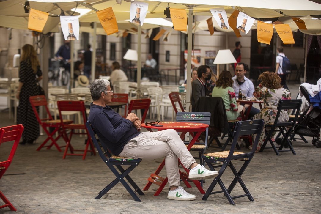 Una persona en un bar decorado con los farolillos tradicionales de la Feria de Abril, suspendida por segundo año consecutivo debido a la pandemia provocada por el coronavirus, Covid-19. En Sevilla (Andalucía, España), a 20 de abril de 2021.