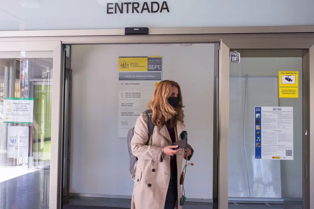 Una mujer entra por la puerta de una oficina del SEPE
