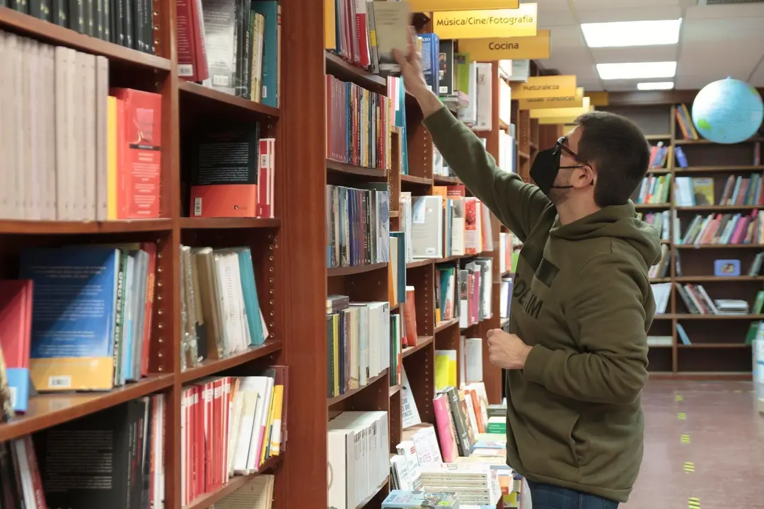 Archivo - Un trabajador coloca libros en una librer&iacute;a. Archivo