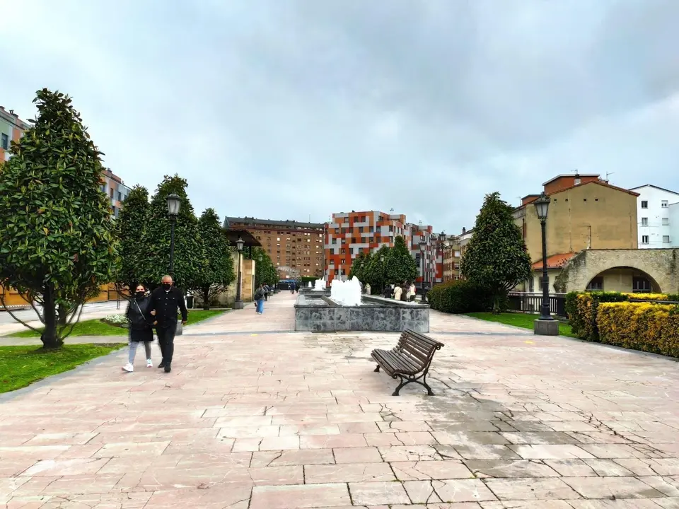 Personas paseando por La Losa de Oviedo en un d&iacute;a de primavera, con mascarillas.
