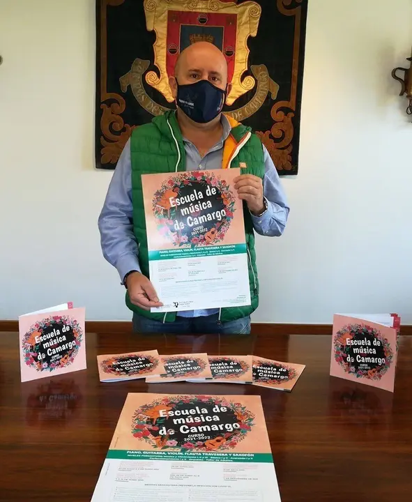 El concejal de Cultura de Camargo, Jos&eacute; Salm&oacute;n, con el cartel anunciador del nuevo curso en la Escuela de M&uacute;sica