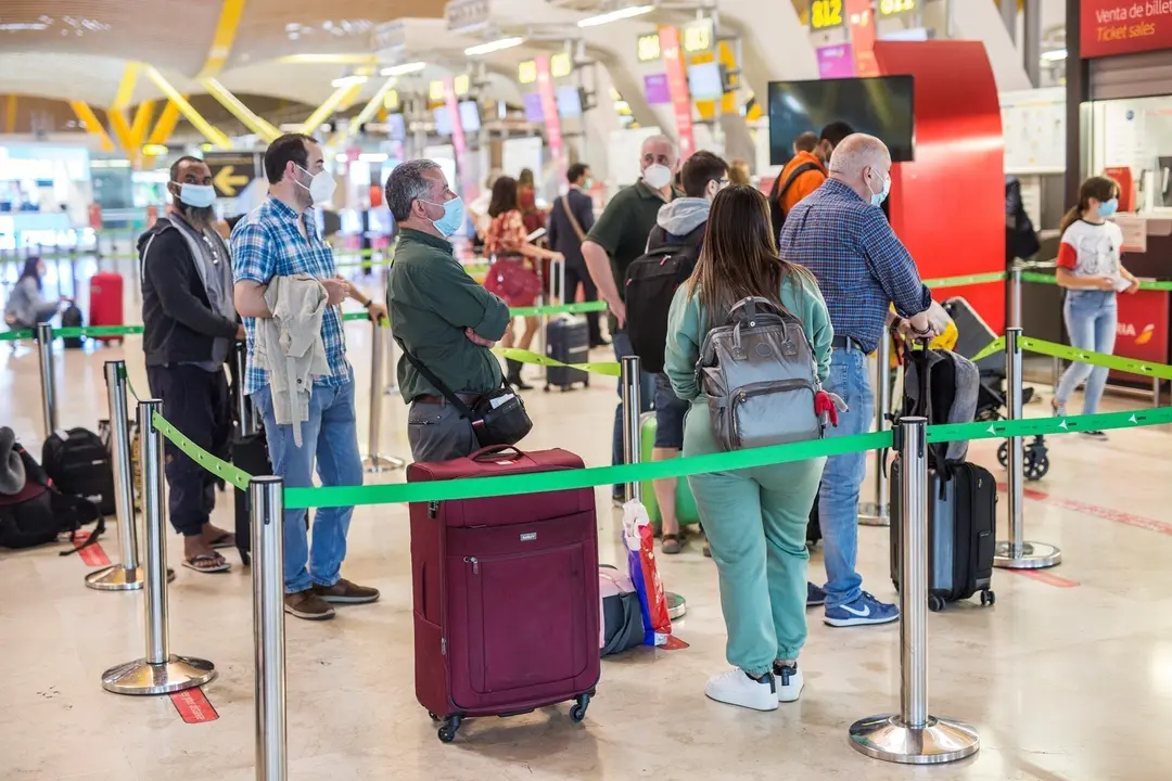 Varias personas hacen fila con maletas en la terminal T4 del Aeropuerto Adolfo Su&aacute;rez Madrid-Barajas, a 21 de mayo de 2021.