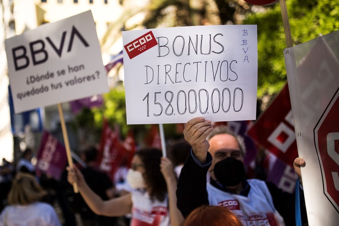 Un hombre sujeta un cartel en el que se lee: "Bonus directivos 158.000.000" durante una concentración contra el ERE de BBVA, en el Paseo de Recoletos, a 17 de mayo, en Madrid (España). 