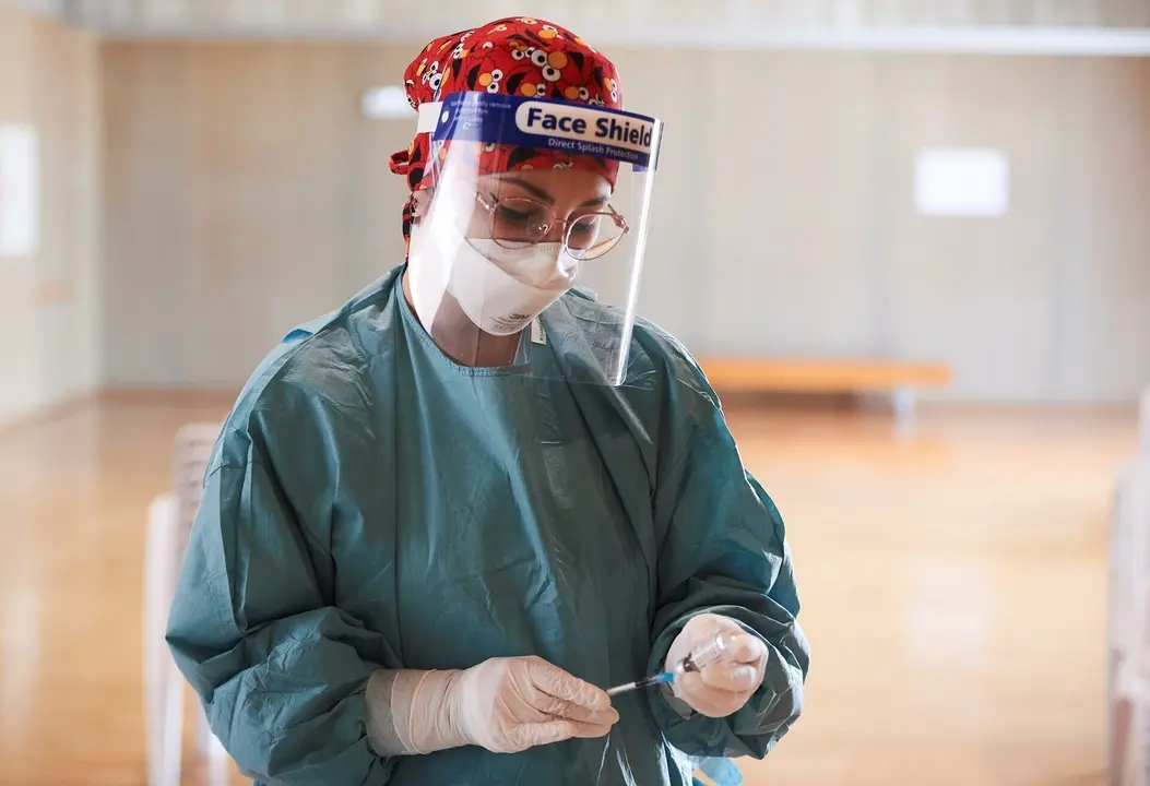 Archivo - Una profesional sanitaria sostiene un vial con la vacuna de AstraZeneca