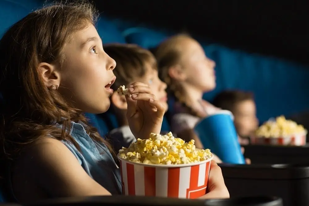 Archivo - Ni&ntilde;os comiendo palomitas en el cine