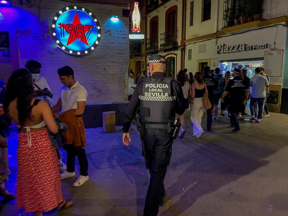 Un policía municipal de Sevilla, le recrimina a un joven que está esperando a la puerta de una discoteca que se coloque la mascarilla  15 de mayo del 2021 en Sevilla, Andalucía