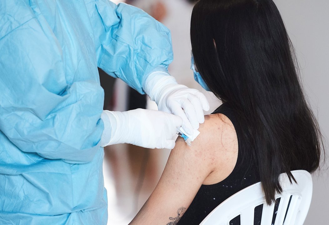 Archivo - Una mujer recibe la vacuna del Covid en Santander 