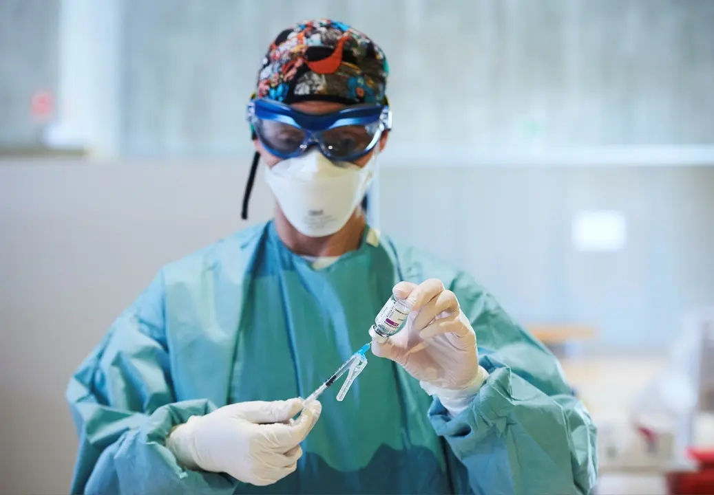 Archivo - Una profesional sanitaria sostiene un vial con la vacuna del coronavirus