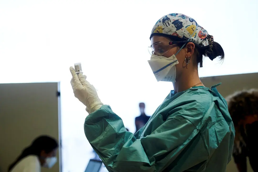 Archivo - Una profesional sanitaria sostiene un vial