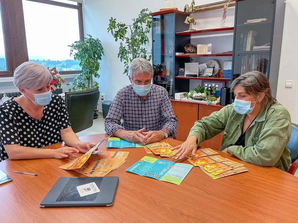 Rosa D&iacute;az Fern&aacute;ndez y los concejales de Cultura y Deporte, Alicia Mart&iacute;nez y Avelino Rodr&iacute;guez, repasando el folleto 'Polanco vive el verano' con al programaci&oacute;n para los meses de julio y agosto.
