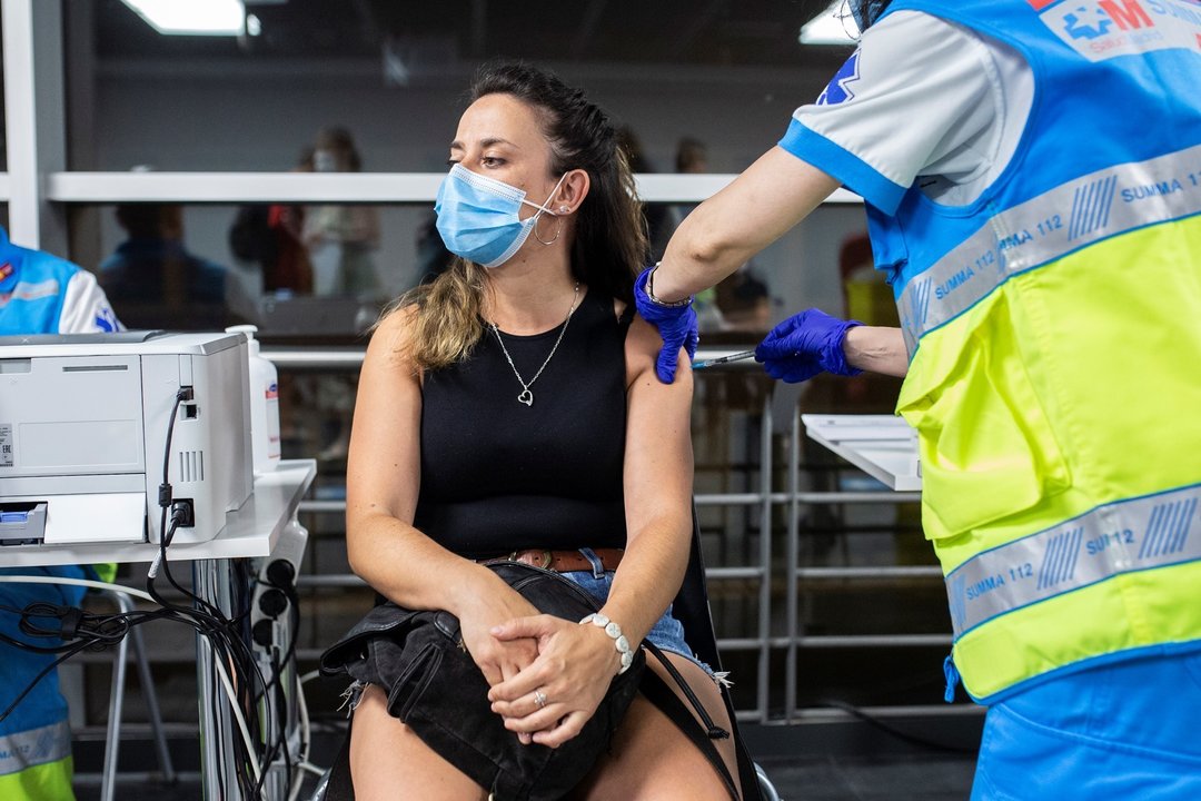Un sanitario administra una dosis de la vacuna de Pfizer a una mujer en el Wizink Center durante la primera noche en la que el recinto está abierto a la vacunación, a 1 de julio de 2021, en Madrid (España).