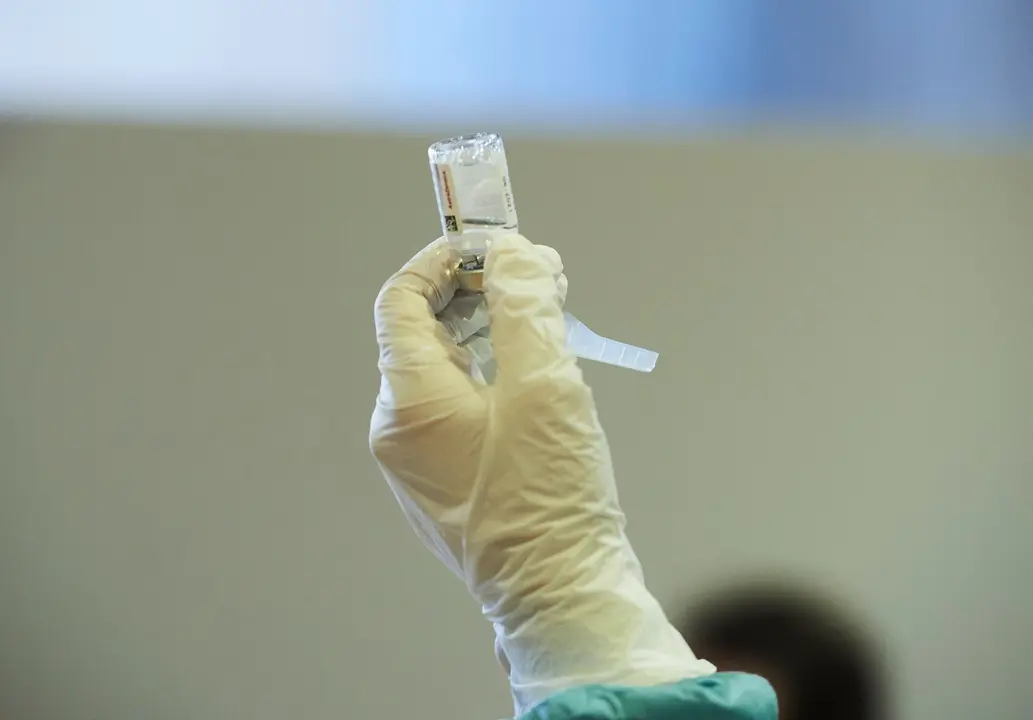 Archivo - Una profesional sanitaria sostiene un vial con la vacuna de AstraZeneca