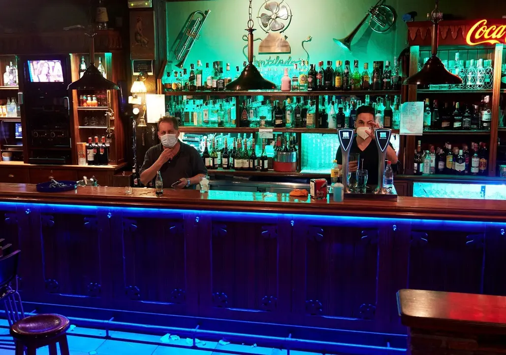 Dos camareros en un local de ocio nocturno, antes de su cierre a medianoche,