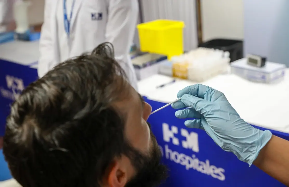 Un sanitario realiza un test de ant&iacute;genos a un hombre